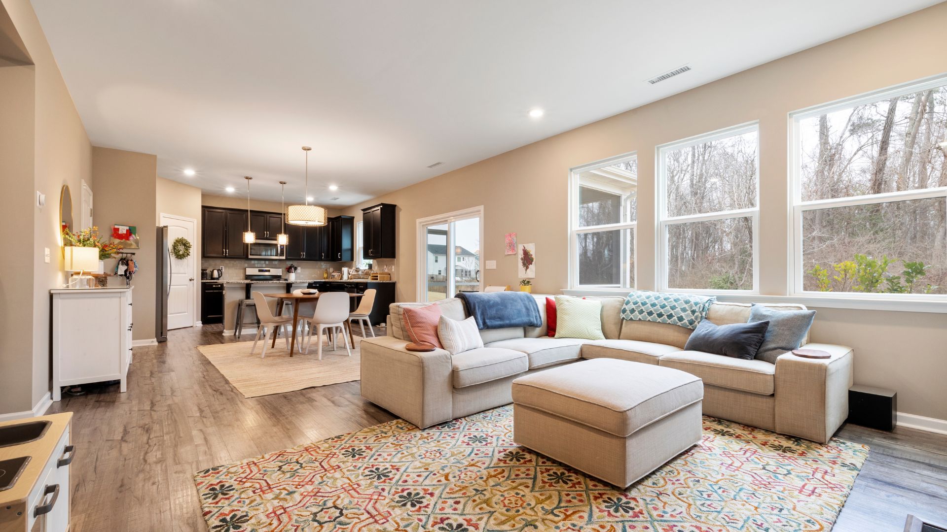 Modern open-concept living space with kitchen, dining area, and cozy sectional sofa