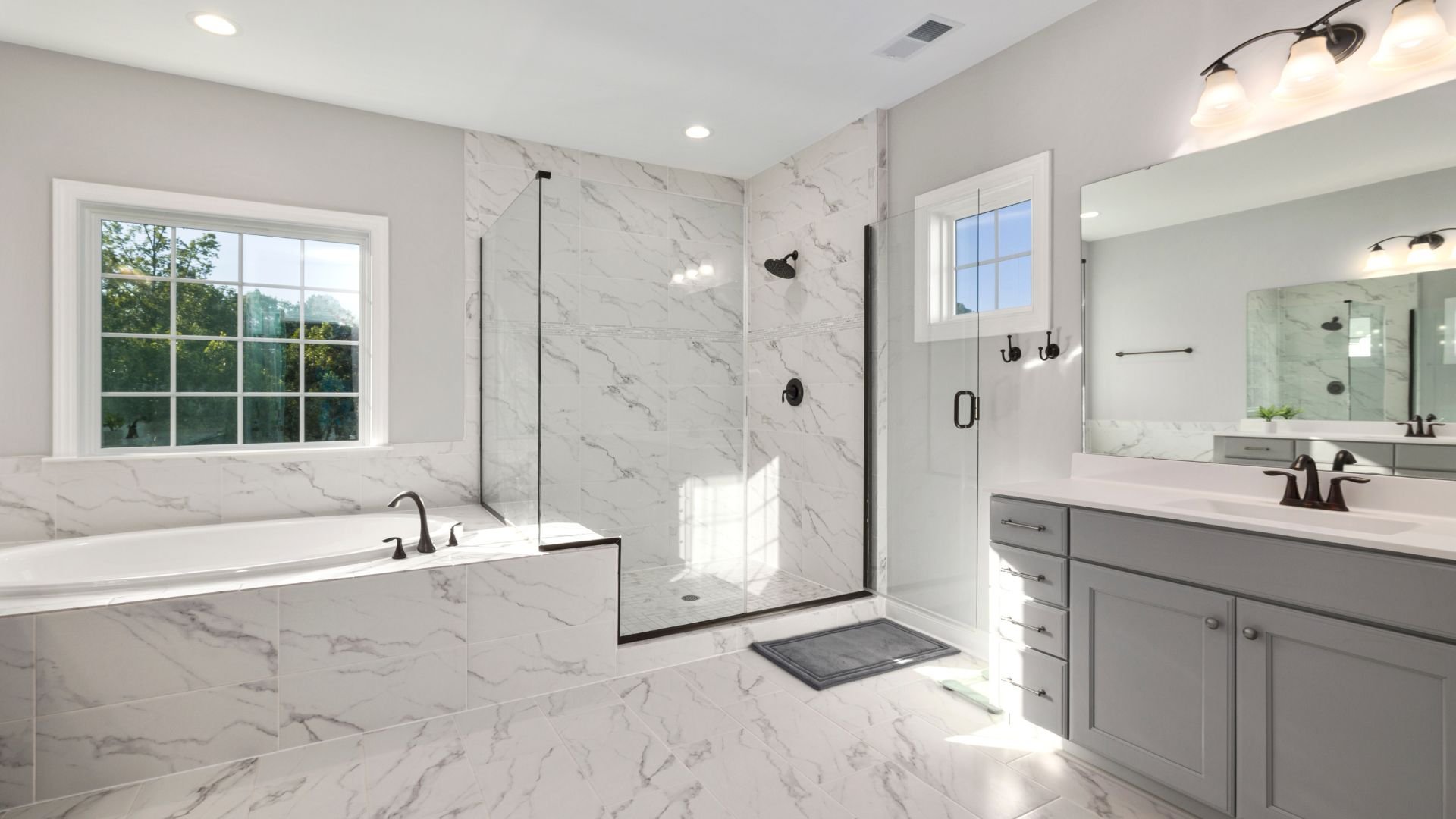Luxurious white marble bathroom with glass shower and large windows